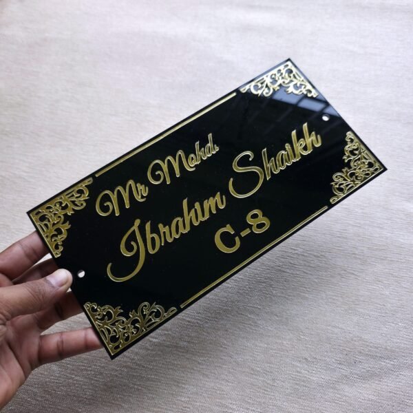 20250830_154604 A hand holding the black and gold acrylic nameplate to show its size and premium finish.