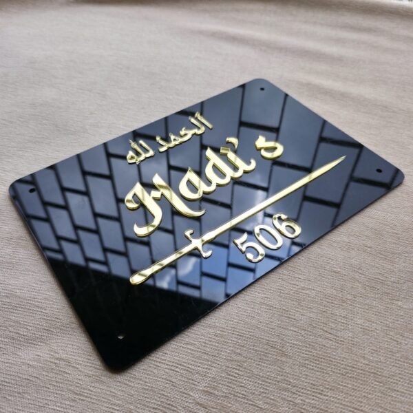 Angled close-up shot of the custom Islamic nameplate, highlighting the reflection and 3D quality of the gold acrylic letters.