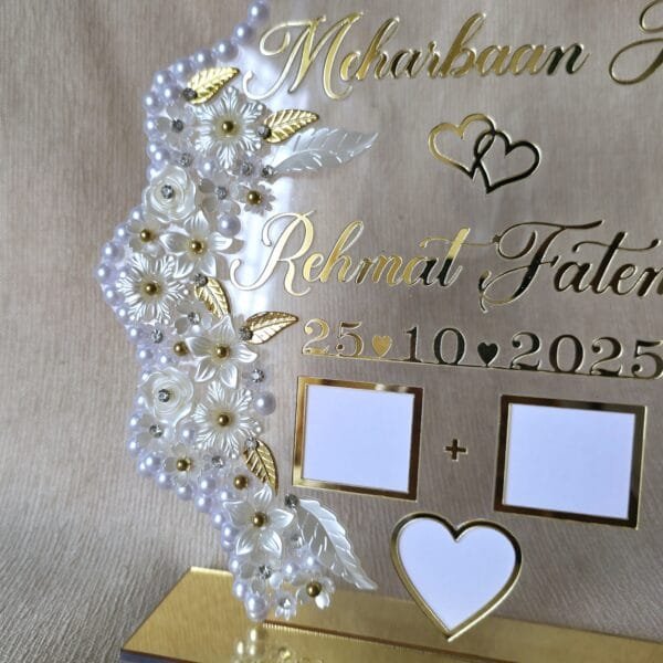 Angled shot of the personalized acrylic Nikah thumb board, highlighting the shimmer of the gold names and the elegant pearl frame against a neutral background.