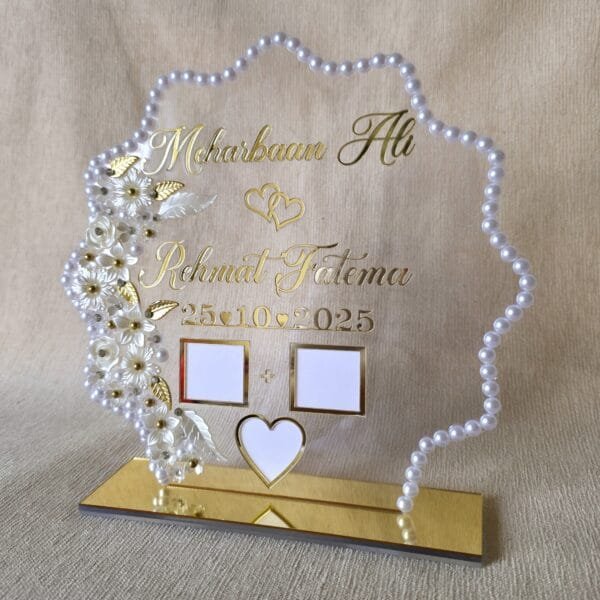 A straight-on, slightly angled photo of the complete Nikah thumb board, clearly displaying the custom names, date, thumbprint slots, and pearl border.