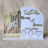 A front-view of a personalised white and gold acrylic engagement thumb board with custom names 'Kashaf' and 'Saklein'.