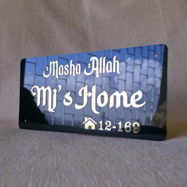Side angle view of a black acrylic nameplate with 'Masha Allah' in reflective white lettering, showing the sky's reflection.