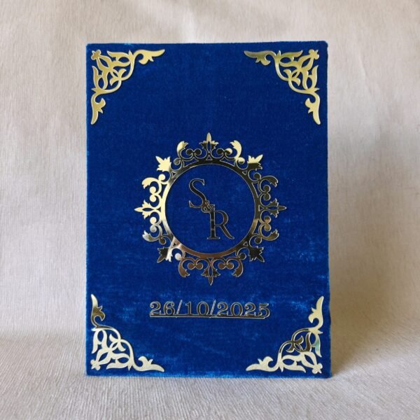 Front view of a royal blue velvet Nikah Nama booklet with a gold acrylic monogram of the initials 'S' and 'R' and the date '26/10/2025'.