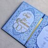 The inside left panel of the Nikah Nama booklet featuring gold acrylic names 'Shafi' and 'Reshma' with two empty heart-shaped slots for photos.