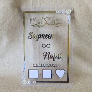 A front-facing view of the personalized silver acrylic Nikah Thumb Board with custom names 'Saymeen' and 'Nafish' on a beige background.